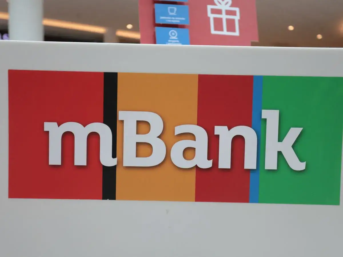 Logo mBank z białymi literami na kolorowym tle: czerwonym, pomarańczowym, czerwonym, niebieskim i zielonym.