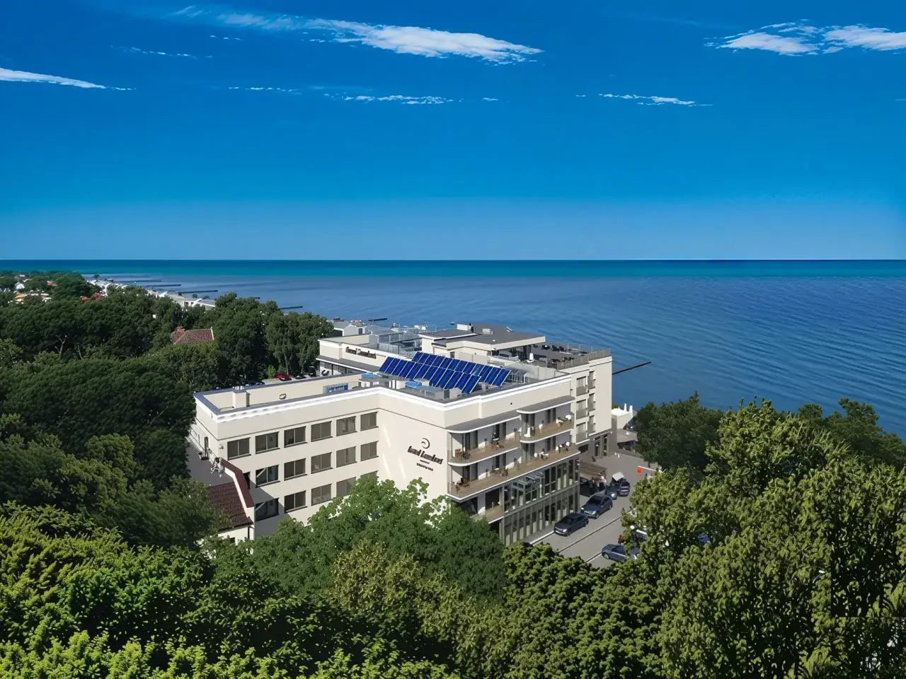 Nowoczesny hotel z panelami słonecznymi nad polskim morzem, otoczony zielenią.