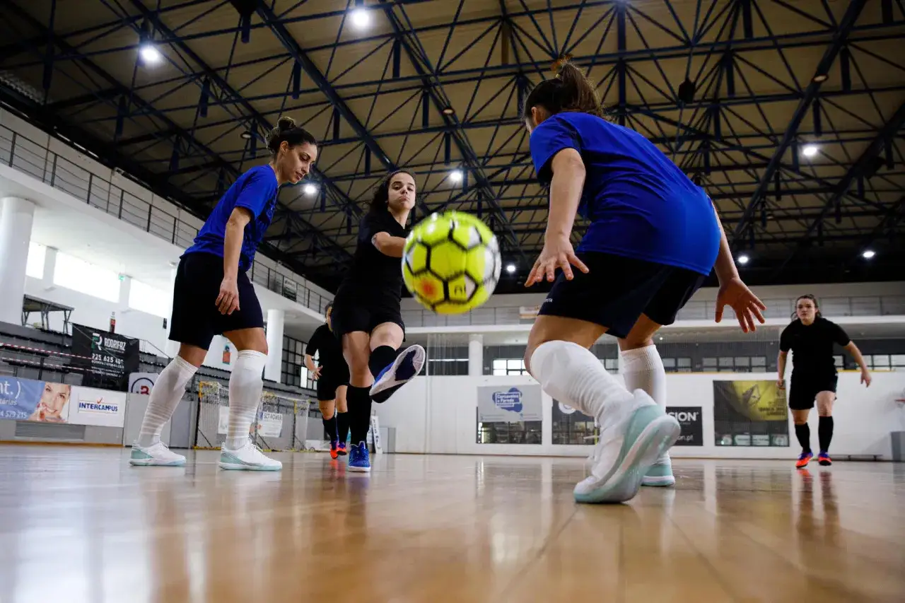 Piłkarki walczą o piłkę na hali. Zastanawiasz się, ile trwa mecz futsalu? To dynamiczna gra, która wymaga szybkości i precyzji.