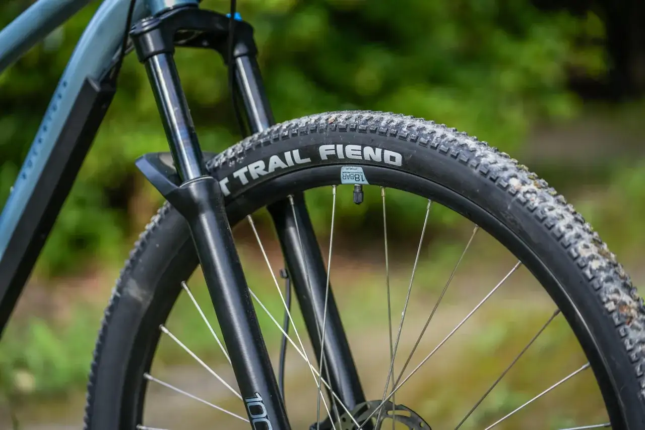 Opona rowerowa "Trail Fiend" z widocznym bieżnikiem, zwijana, gotowa na terenowe wyzwania.