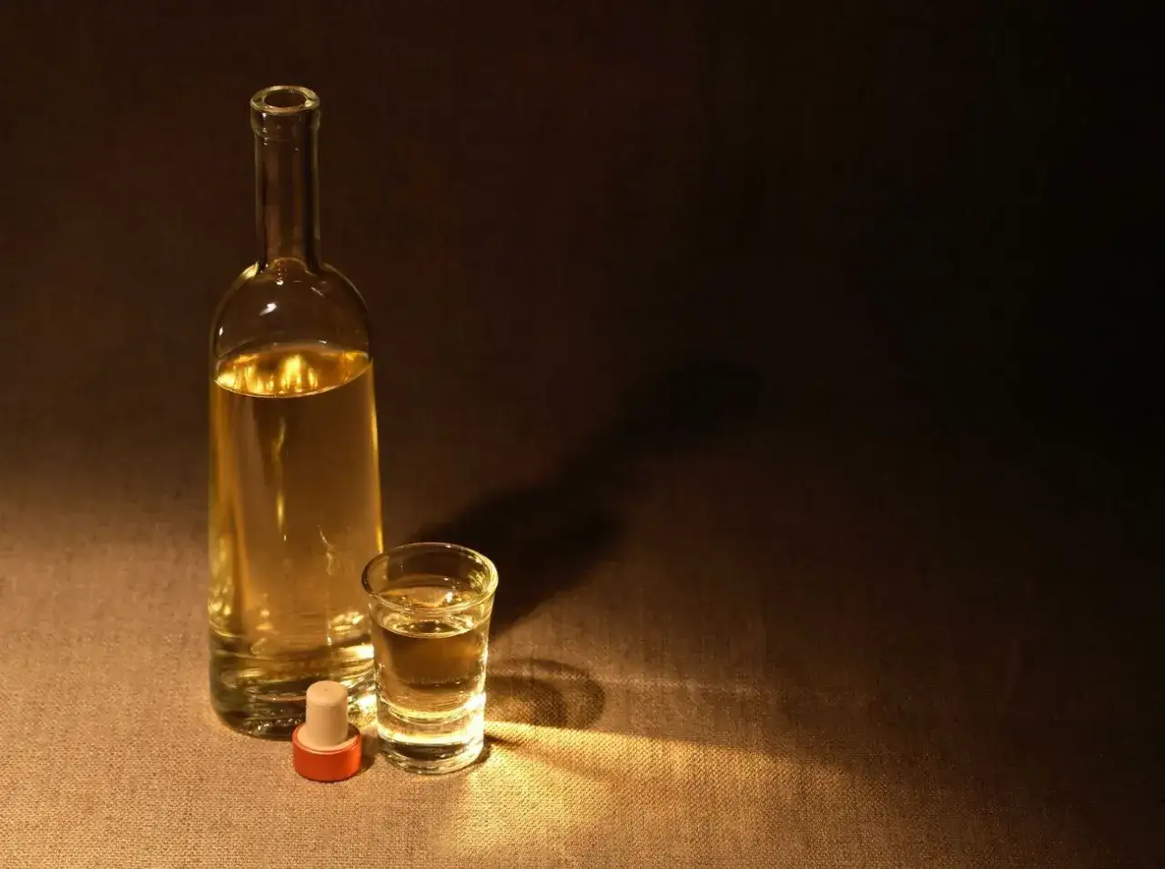 Szklana butelka i kieliszek z płynem, który może być bimbrem. Czy bimber się pali?