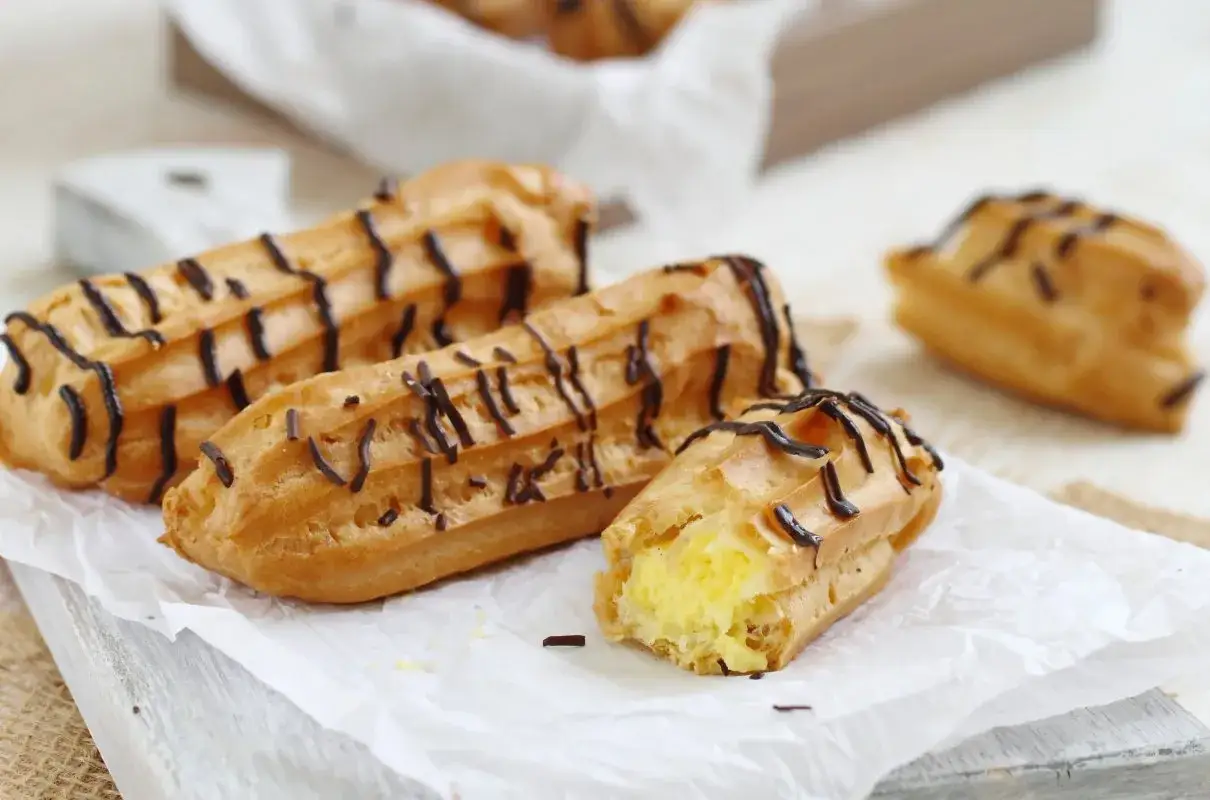 Pyszne eklerki przepis na ciasto ptysiowe z kremem i polewą czekoladową. Idealne na deser!