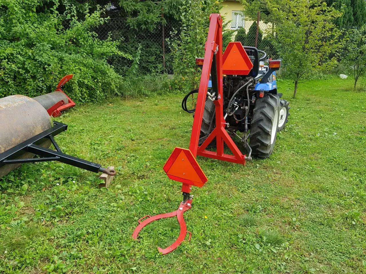 Czerwony podnośnik do traktorka kosiarki, gotowy do pracy. Pokazuje, jak zrobić podnośnik do traktorka kosiarki.