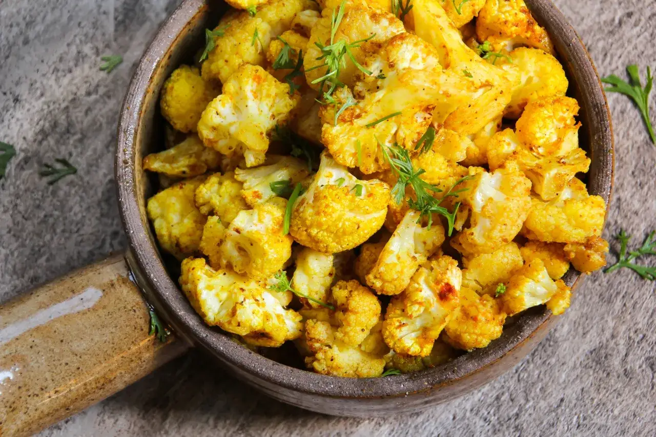 Złocisty, przyprawiony kalafior w misce. Świetny pomysł, co zrobic z ugotowanym kalafiorem, by był pyszny i aromatyczny.