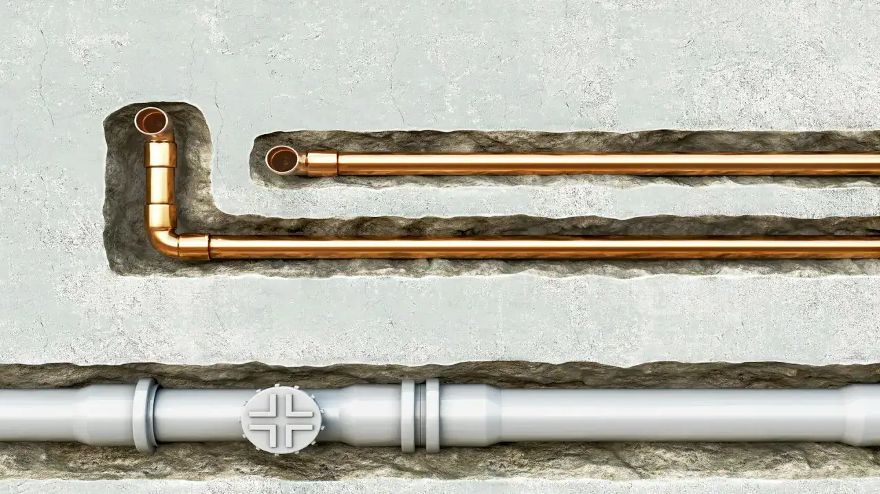 Miedziane i białe rury hydrauliczne w ścianie.