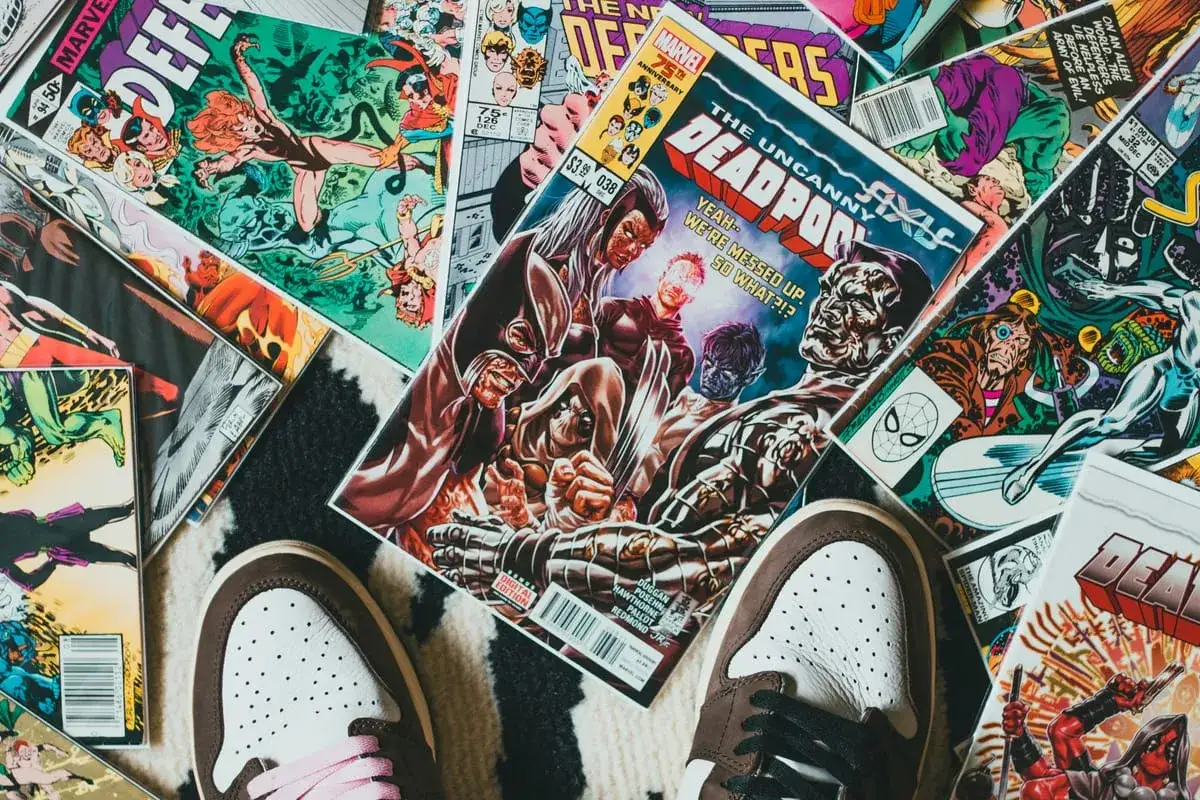 Kolekcja komiksów Marvela, w tym "The Uncanny X-Men" i "Deadpool", leży na dywanie. Idealne dla tych, którzy chcą wiedzieć, jak czytać komiksy Marvela.