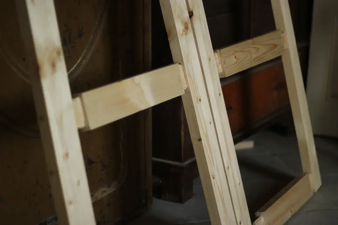 Drewniana konstrukcja, która może posłużyć do nauki, jak zrobić futrynę drewnianą. Elementy są połączone w narożnikach.