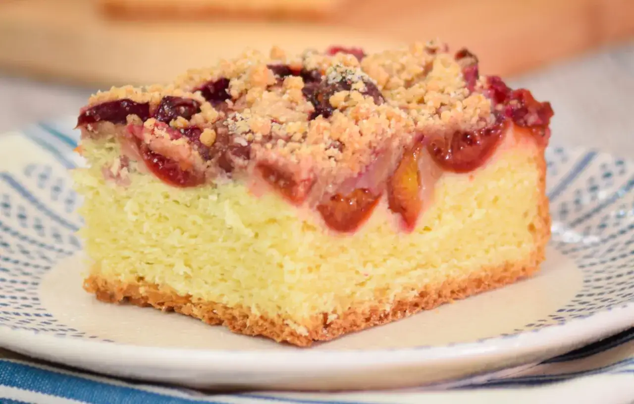 Kawałek ciasta z owocami i kruszonką na talerzyku.