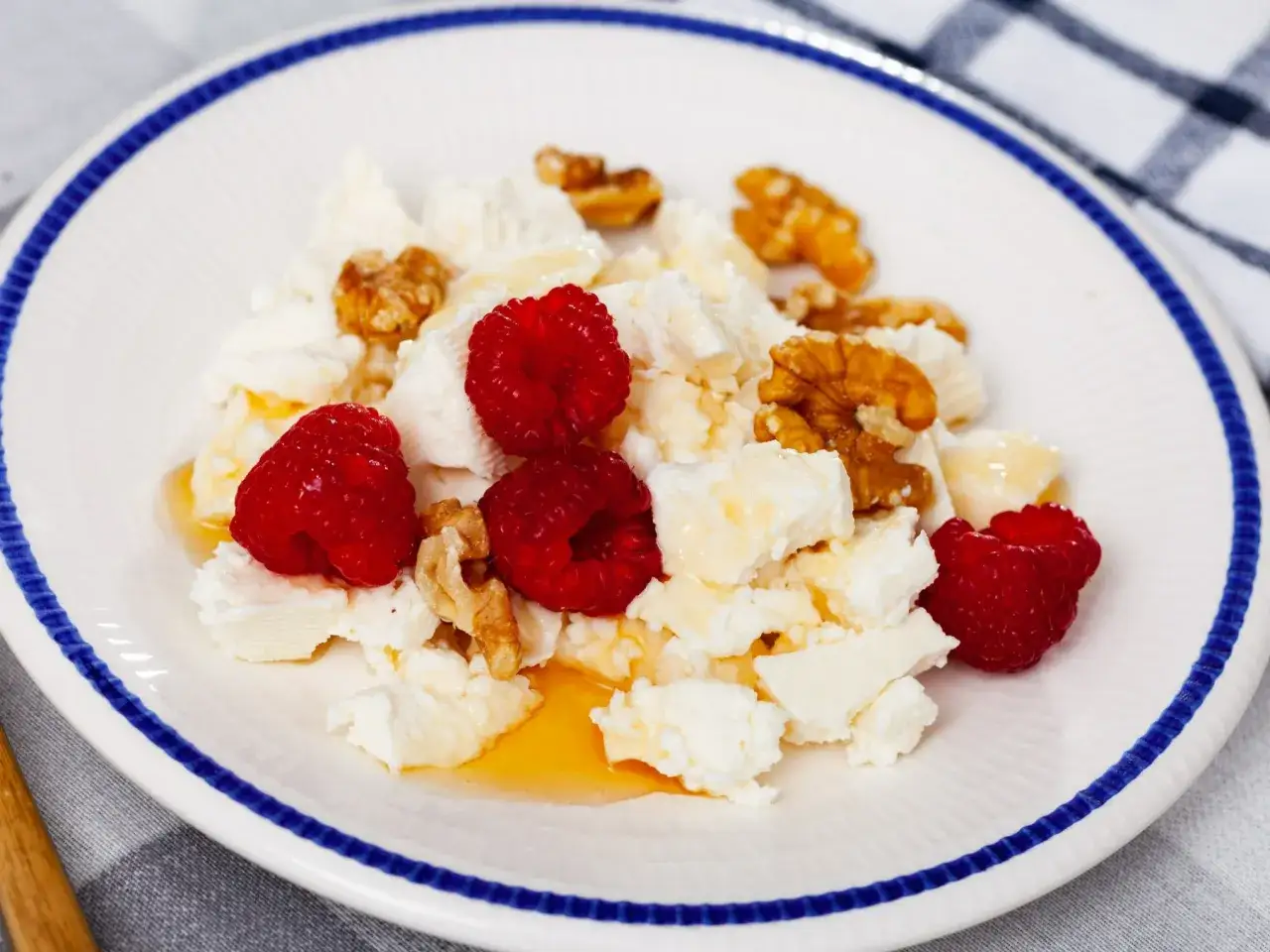 Pyszny twaróg z malinami i orzechami, polany miodem. Idealny pomysł na to, co na obiad z twarogiem.