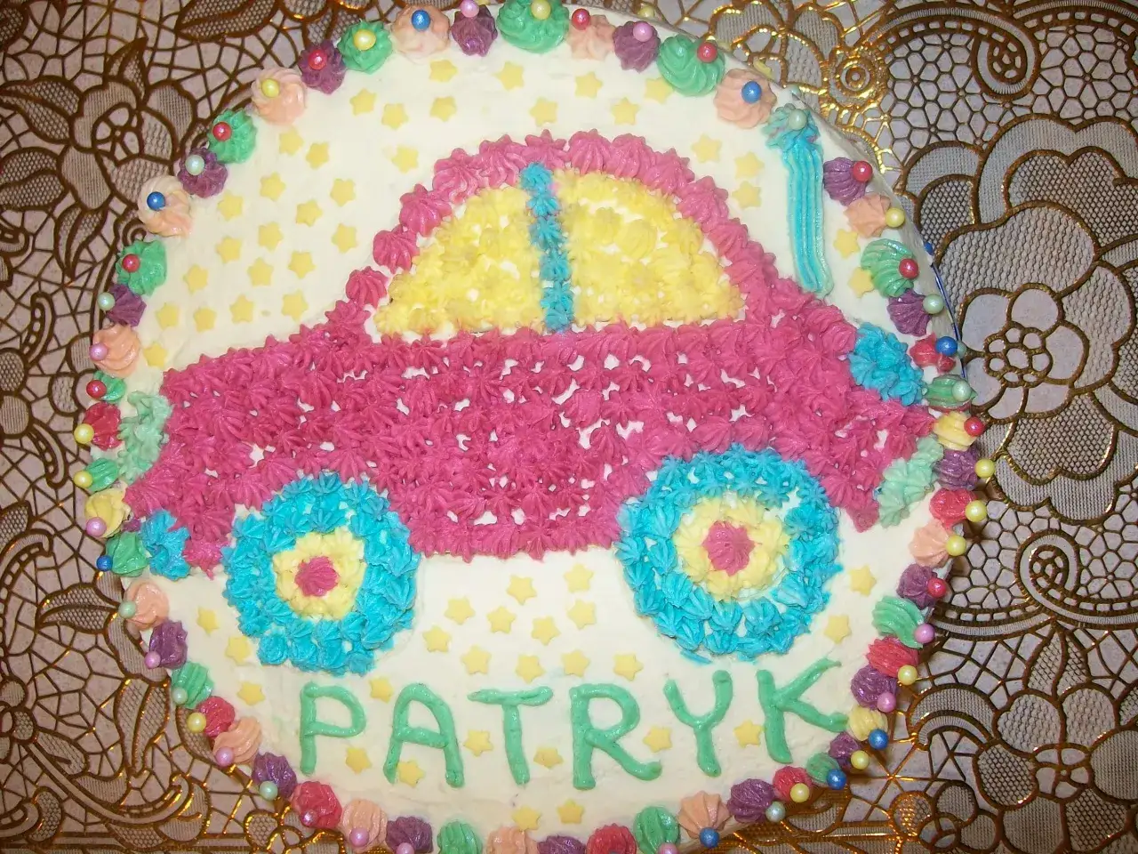 Kolorowy tort w kształcie samochodu z imieniem Patryk.