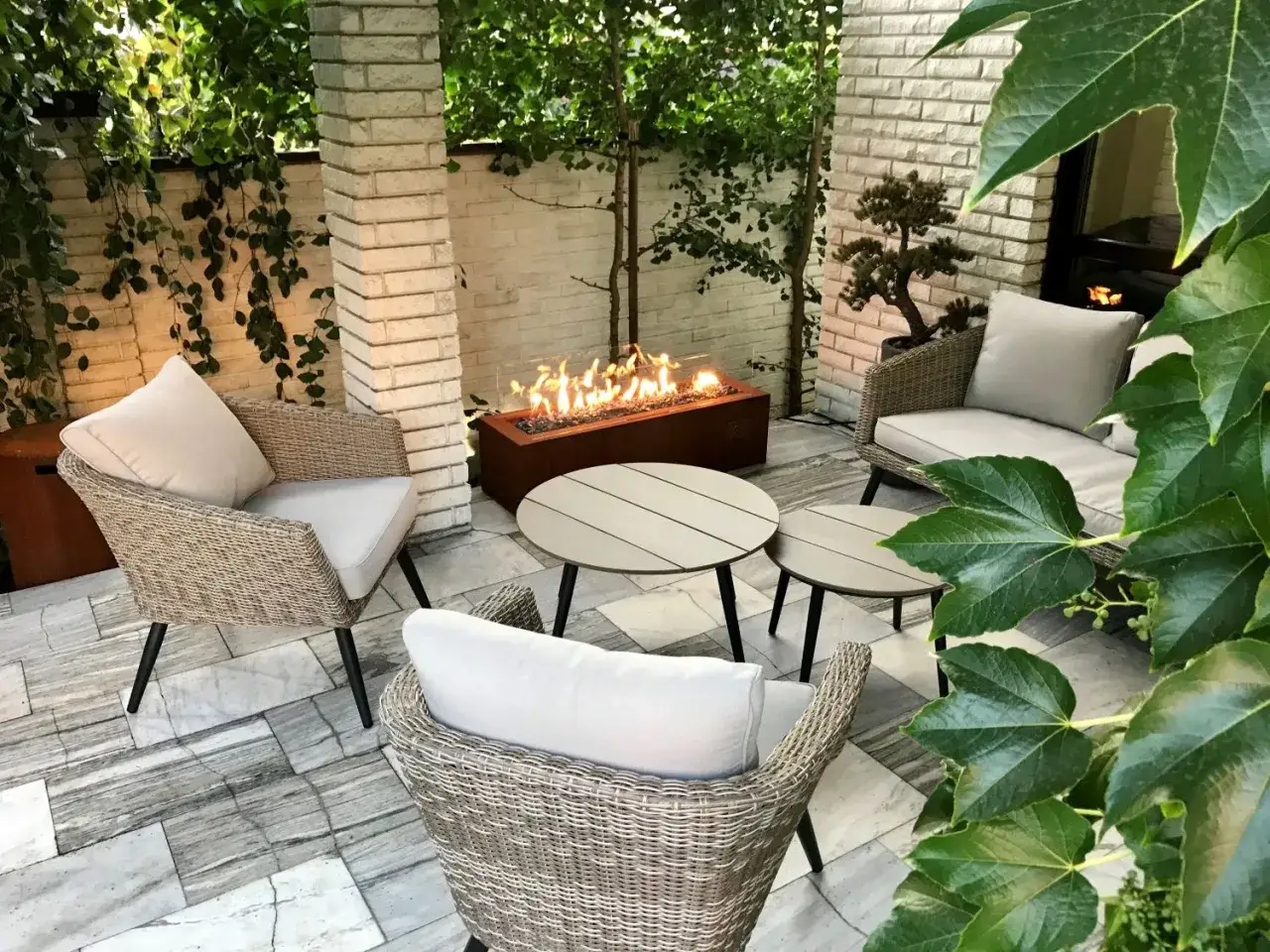 Nowoczesna pergola z paleniskiem gazowym. Wygodne fotele i stoliki tworzą przytulne miejsce do relaksu. Idealne jak postavit krb v pergole.