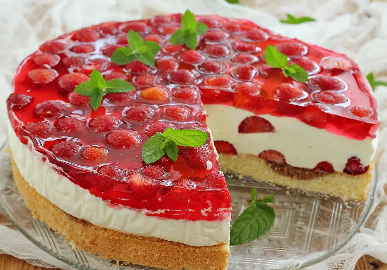 Pyszny tort z galaretką i truskawkami. Czy rozmrażać truskawki do galaretki? Tak, aby były soczyste i pięknie wyglądały w deserze.