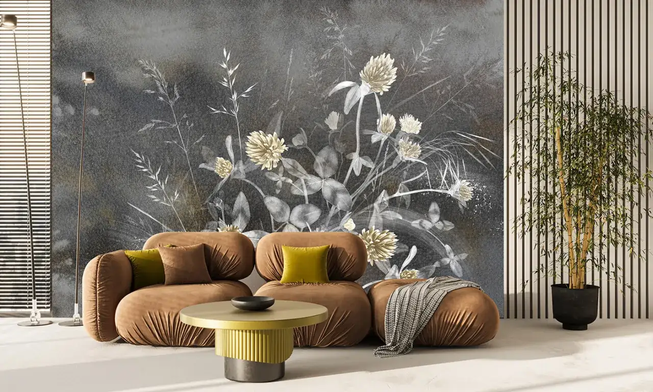 Nowoczesna, tania tapeta z motywem polnych kwiatów na ciemnym tle. Brązowa kanapa i żółty stolik dodają przytulności.