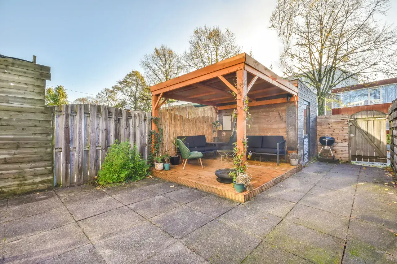 Drewniana altana z palet, idealna na letnie wieczory. Wygodne sofy i stolik zachęcają do relaksu.