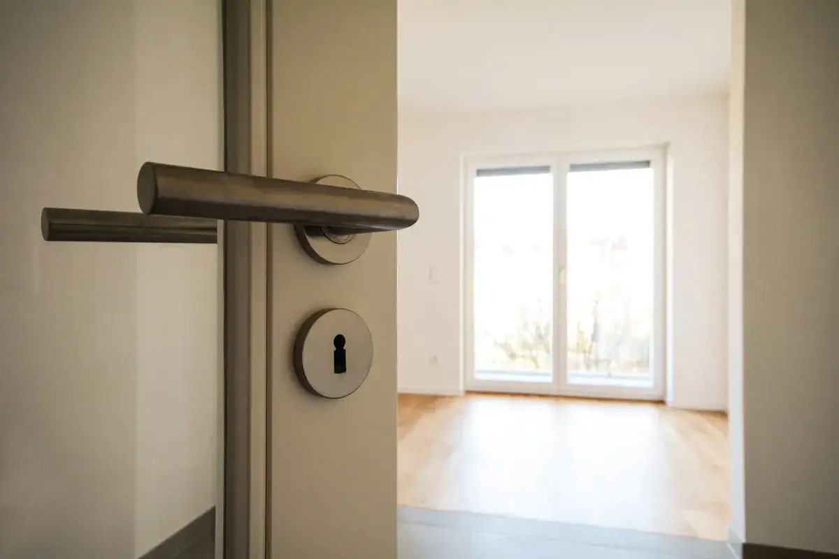 Otwarcie drzwi do pustego mieszkania. Zastanawiasz się, ile kosztuje kawalerka w Niemczech?