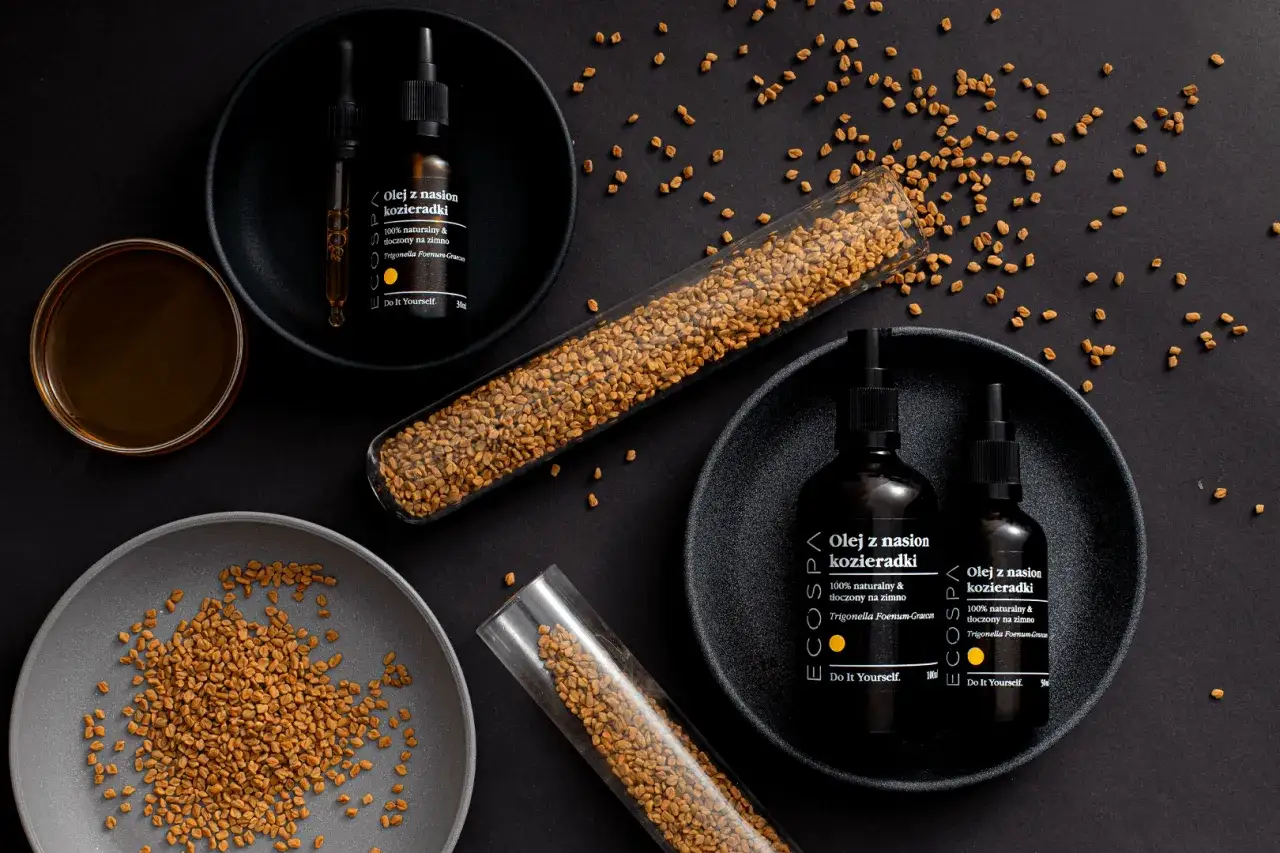 Olej z nasion kozieradki, który może być używany do przygotowania przynęty na ryby. Widać nasiona i buteleczki z olejem.
