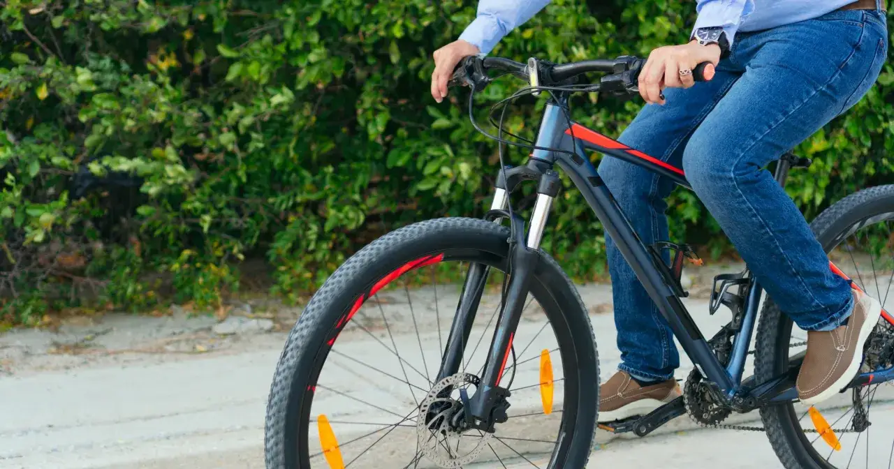 Osoba na rowerze cieszy się aktywnością na świeżym powietrzu. Co daje jazda na rowerze? Zdrowie, radość i kontakt z naturą.