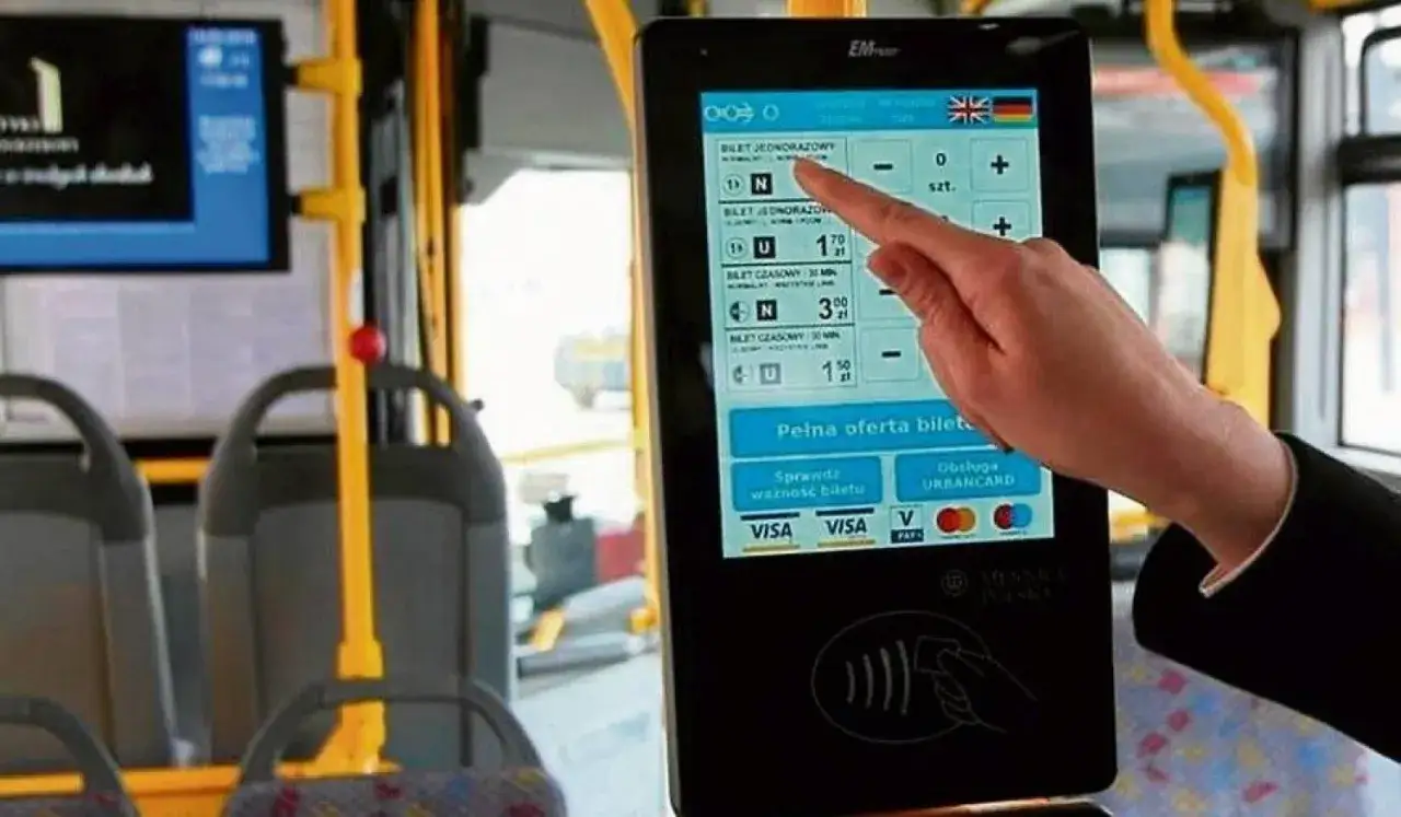 Ręka dotyka ekranu automatu biletowego w autobusie. Czy we Wrocławiu uczniowie jeżdżą za darmo? Tu kupisz bilet, sprawdzisz jego ważność i zapłacisz kartą.