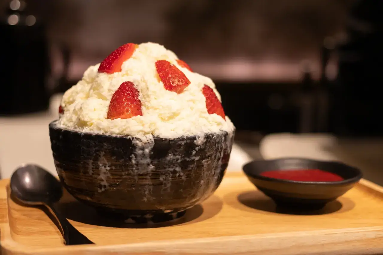 Puszysty deser lodowy z truskawkami, podany z sosem. Czy desery lepiej jeść przed głównym posiłkiem?
