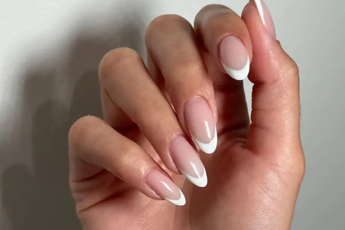 Dłonie z klasycznym french manicure. Czy french jest jeszcze modny? Zdecydowanie tak, wygląda elegancko i ponadczasowo.