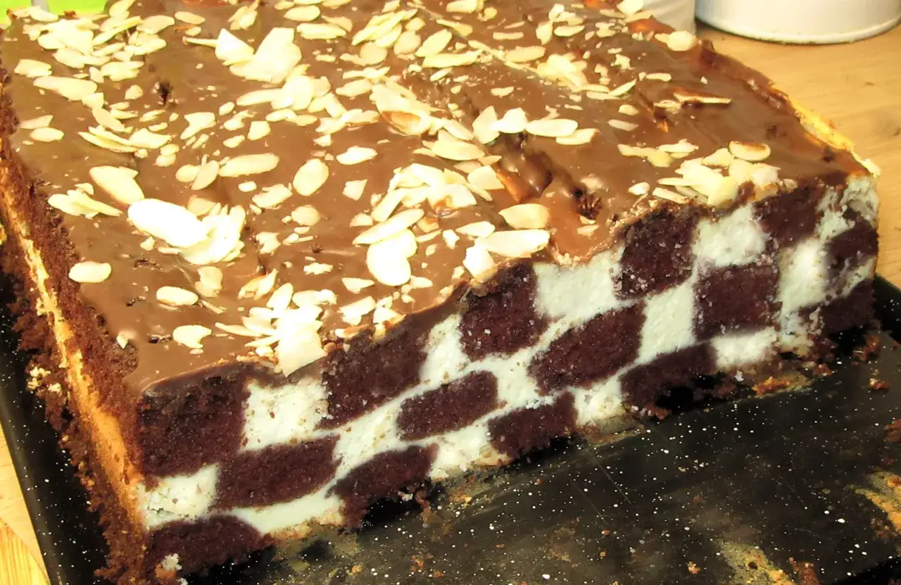 Ciasto szachownica z bitą śmietaną przepis. Czekoladowe ciasto z kremowym nadzieniem, posypane płatkami migdałów.