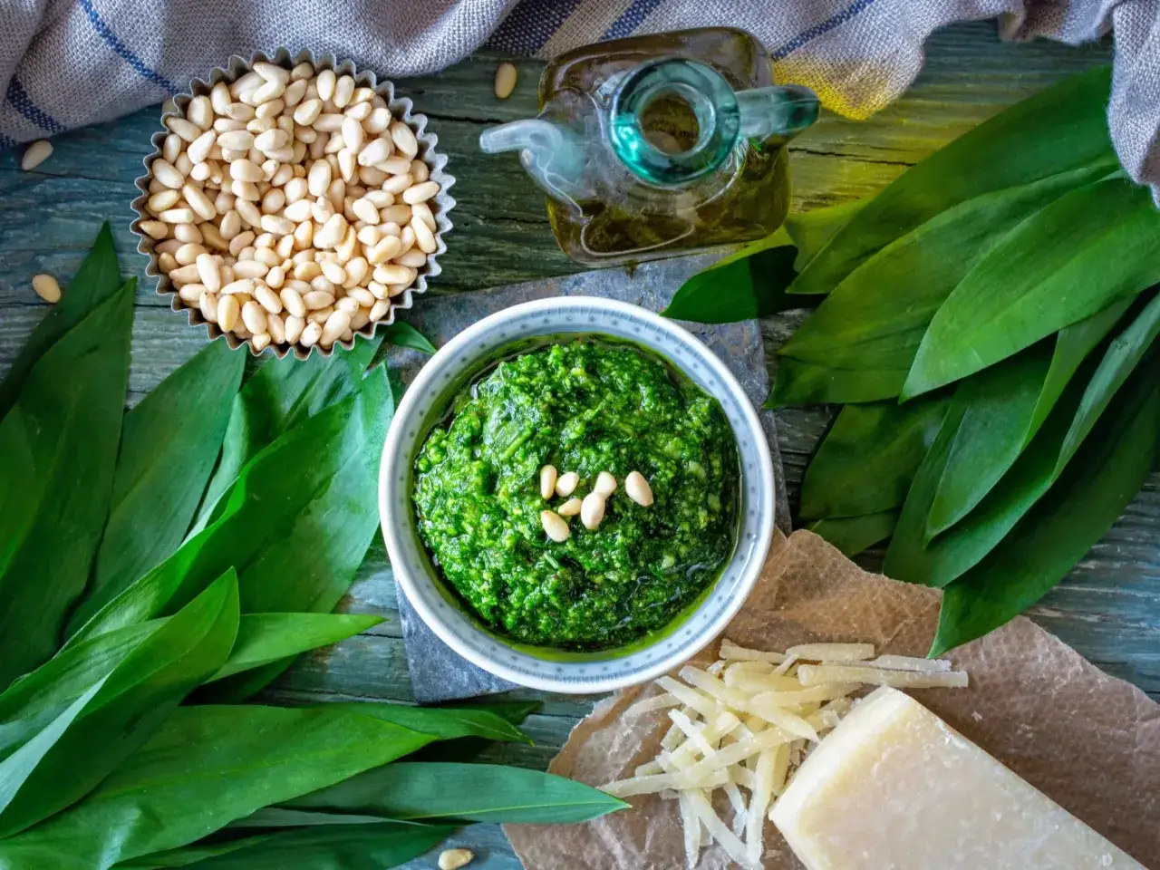 Pesto z czosnku niedźwiedziego, orzechów pinii i oliwy. Obok kawałek sera, który może być alternatywą, jaki ser do pesto zamiast parmezanu?