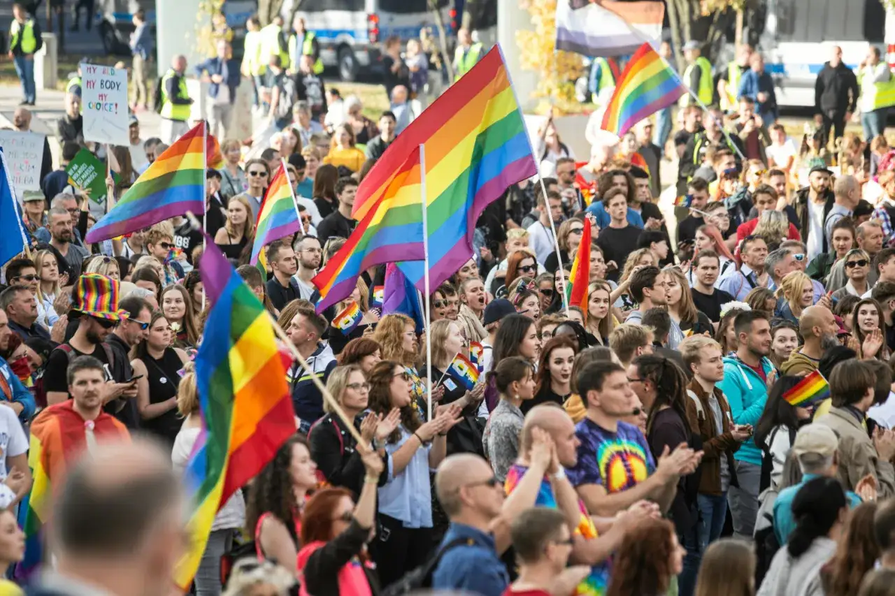 Tęczowe flagi na marszu. Dlaczego tęcza jest symbolem LGBT? Kolory symbolizują różnorodność społeczności i nadzieję na równość.