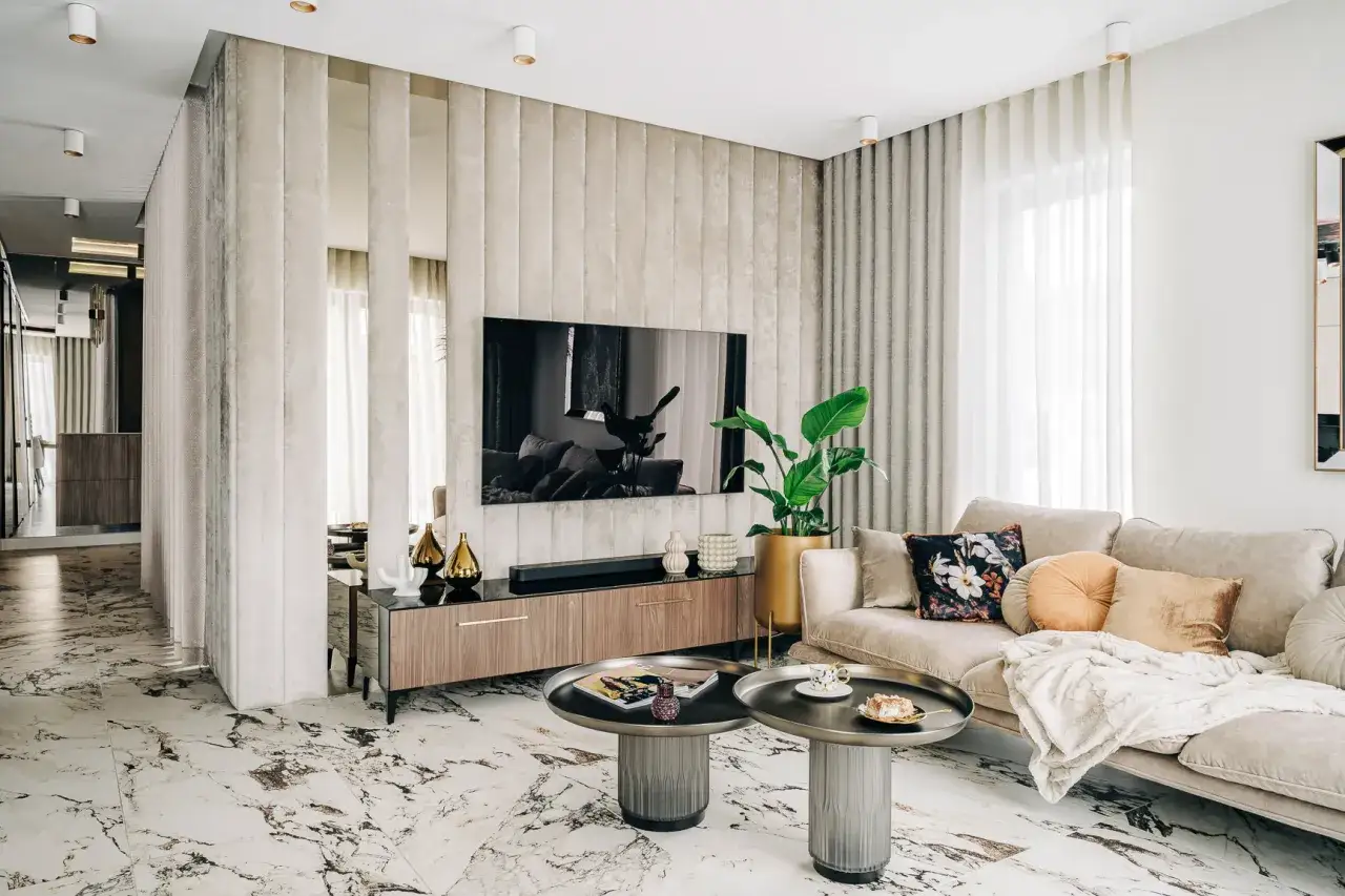 Nowoczesny salon z kanapą, stolikami i telewizorem. Panelowa ściana za telewizorem tworzy efekt 3d na ścianie.