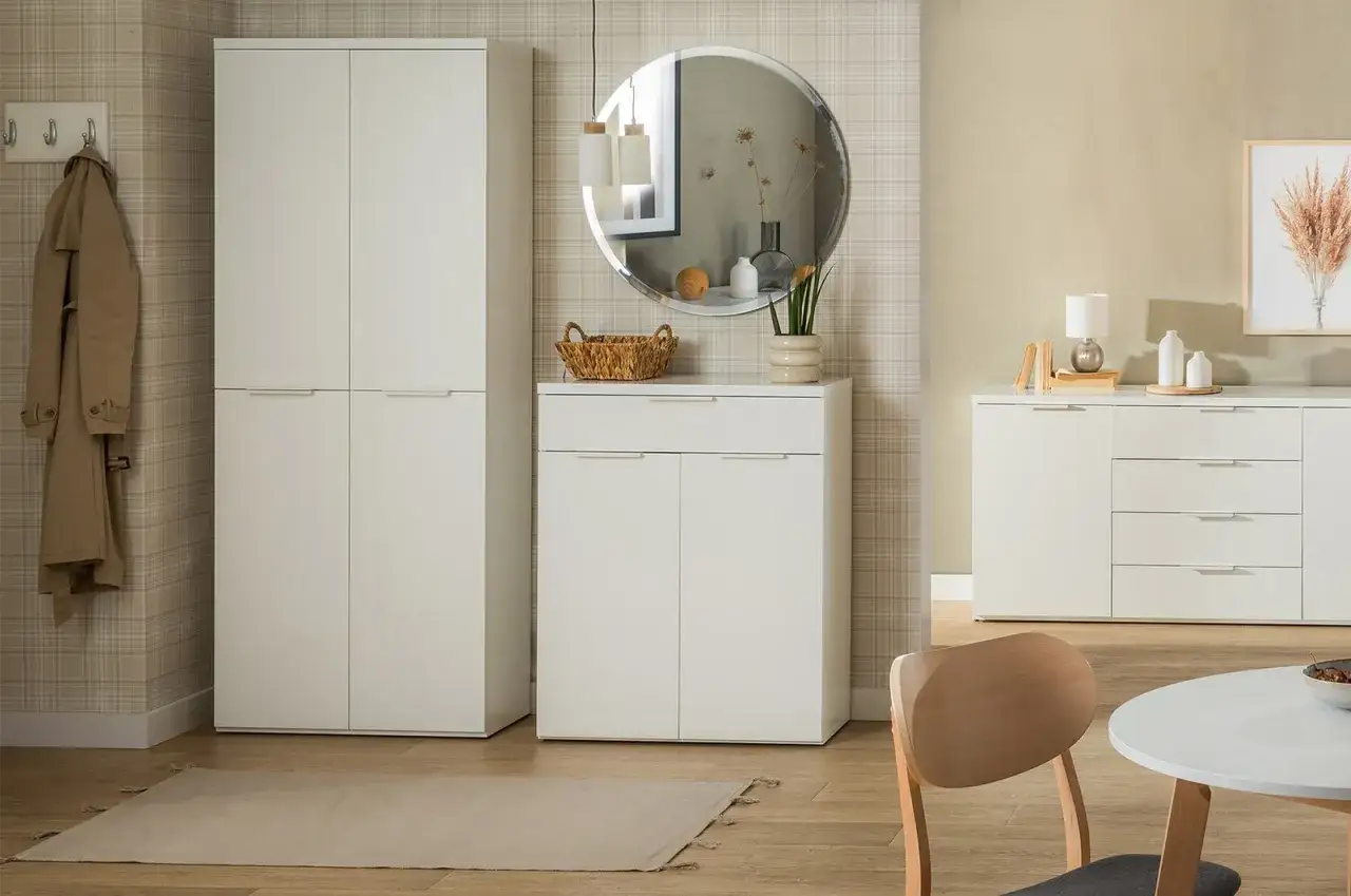 Nowoczesny przedpokój z tapetą w kratę, białe meble, lustro i płaszcz na wieszaku.