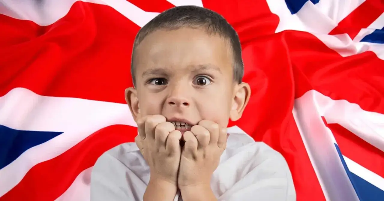 Przerażony chłopiec przed flagą Wielkiej Brytanii. Czy tak wygląda nauka jak nauczyć się mówić po angielsku?