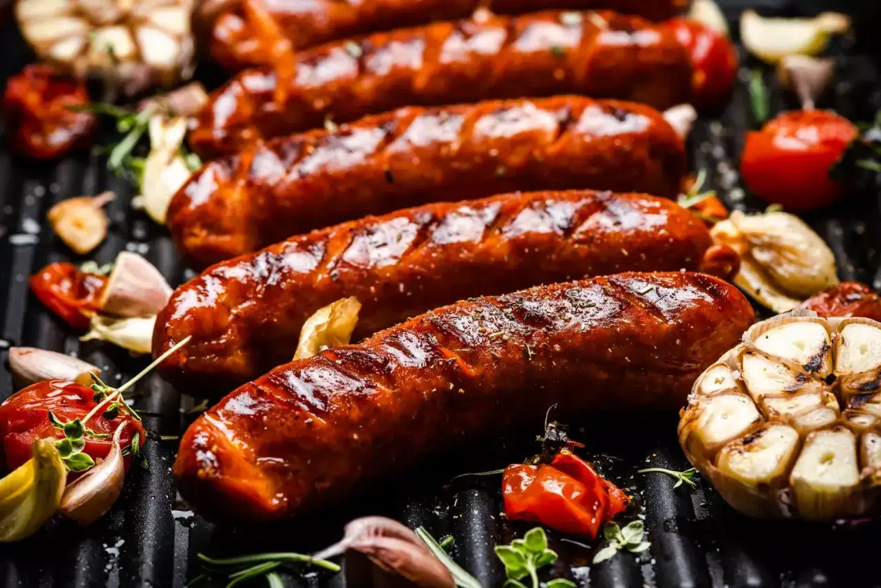 Soczyste kiełbaski na grillu, z czosnkiem i pomidorkami. Idealna odpowiedź na pytanie: jaka kiełbasa na grilla?