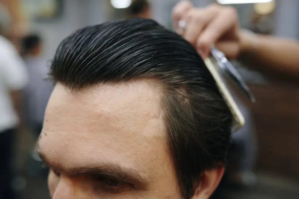 Profesjonalny styling włosów: grzebień i nożyczki w akcji, tworząc idealną fryzurę.