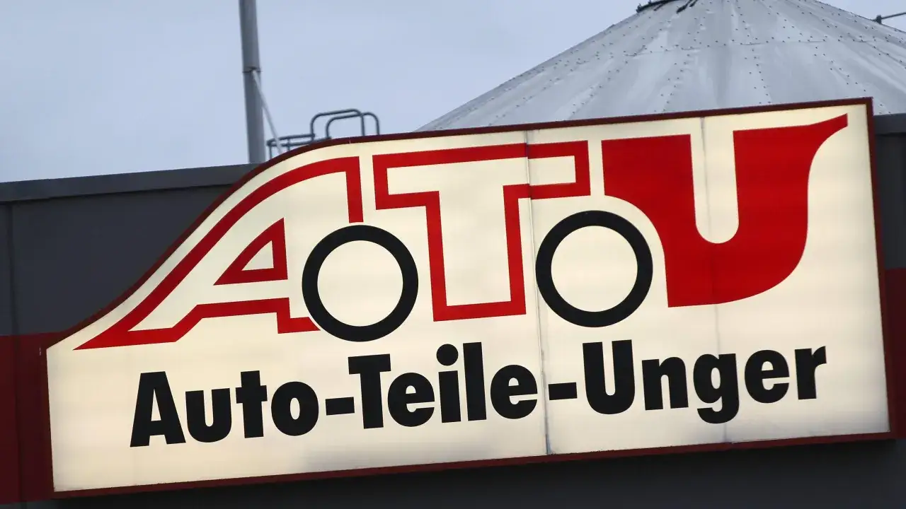 Leuchtreklame von A.T.U. Auto-Teile-Unger mit rotem Schriftzug und weißem Hintergrund.