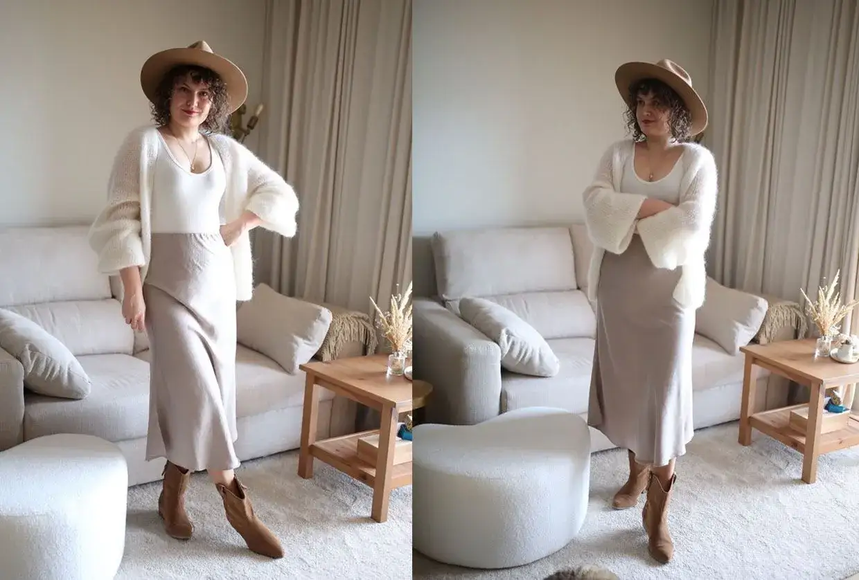 Kobieta w beżowej spódnicy, białym swetrze i kapeluszu pozuje na tle salonu.