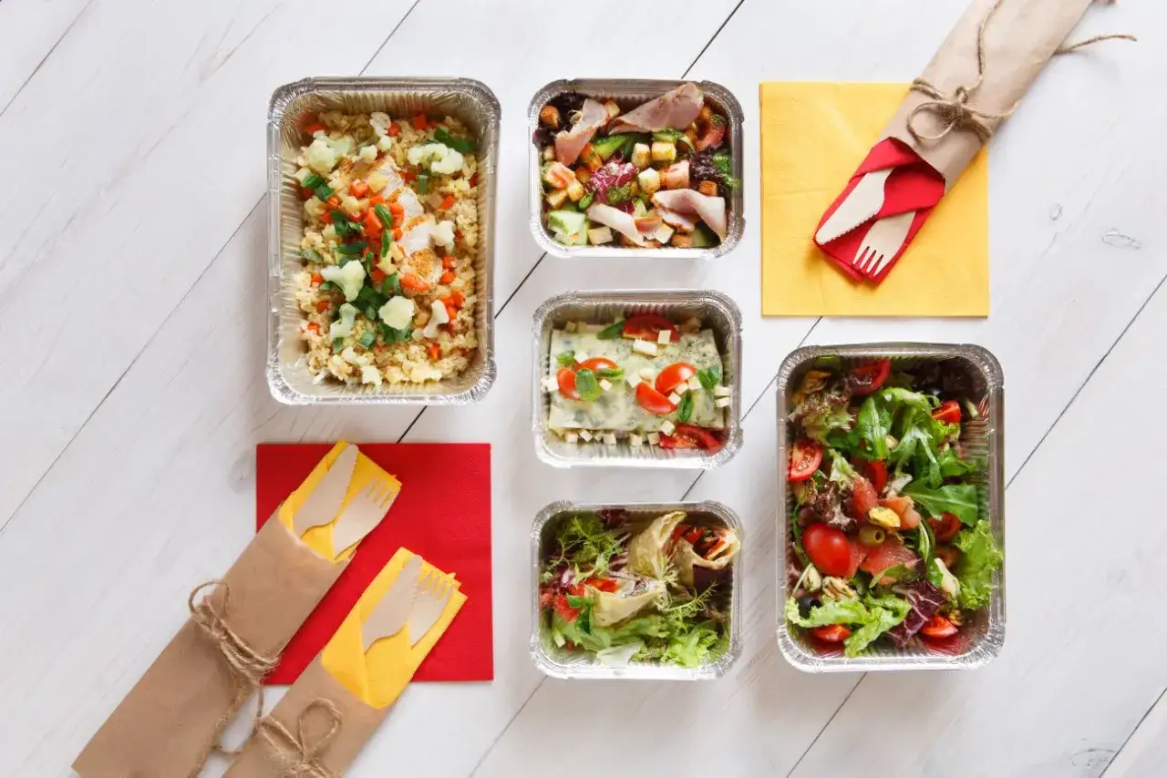 Pyszne jedzenie w pojemnikach: ryż z warzywami, sałatka, lasagne, wrap. Zastanawiasz się, ile kosztuje catering na 60 osób?