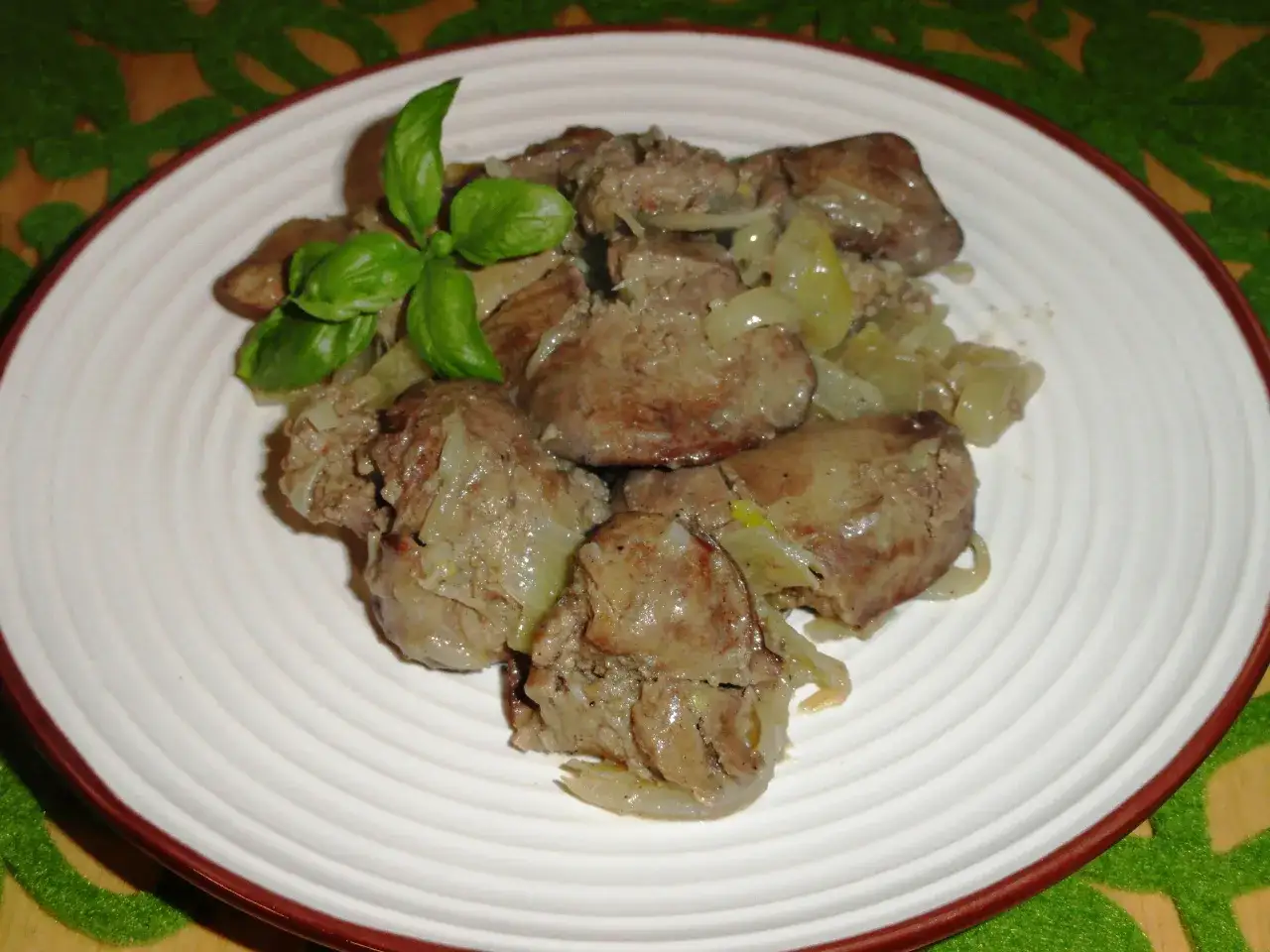 Porcja wątróbki z cebulką na talerzu. Czy roczne dziecko może jeść wątróbkę? To danie wygląda apetycznie.