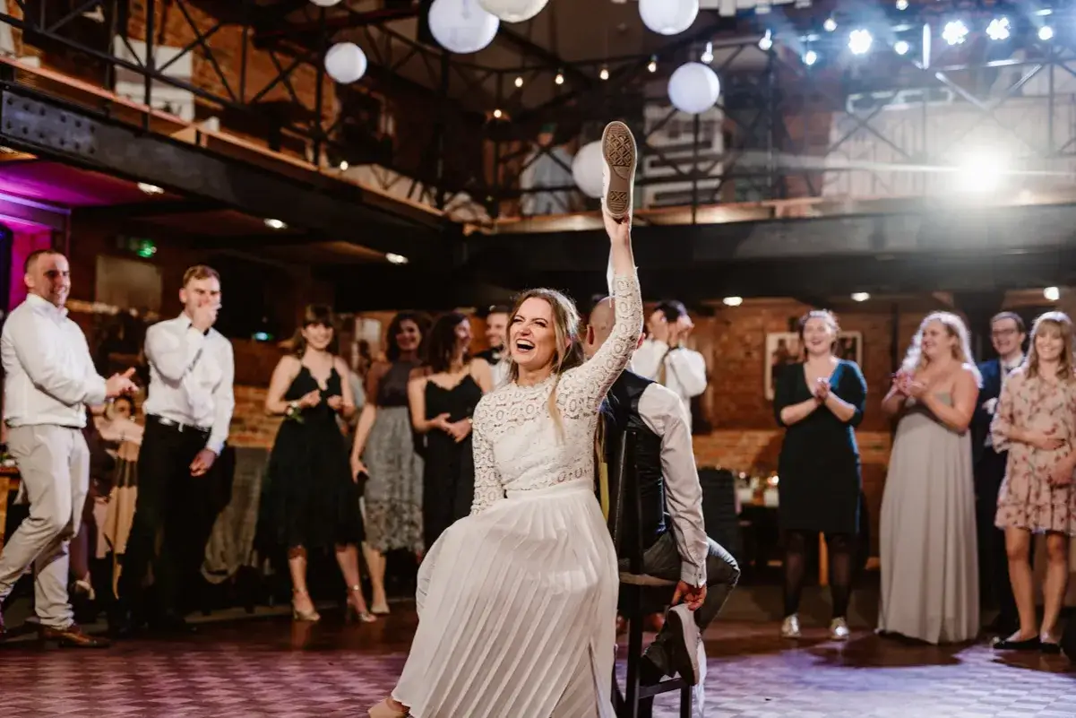 Zabawa weselna: panna młoda podnosi buta, by wyznaczyć przyszłego pana młodego. Unikaj zachowań, które mogą być uznane za objawy bycia "trudnym gościem" na imprezie.