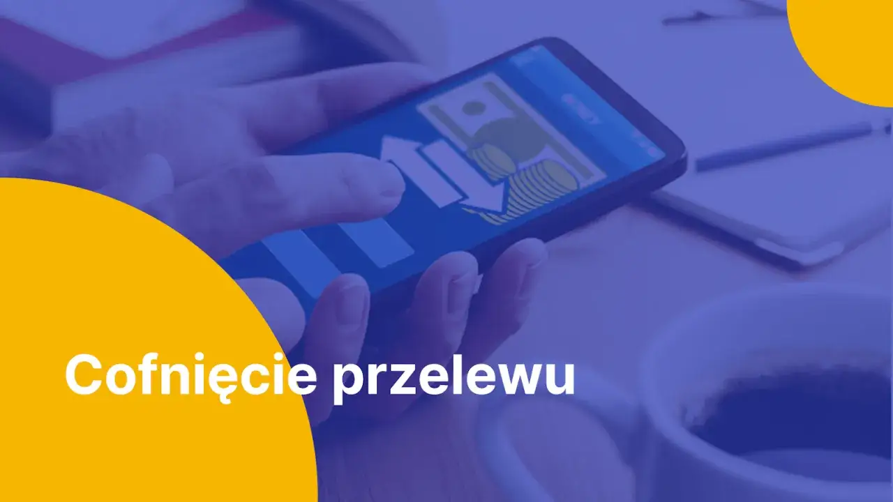 Dłoń trzyma smartfon z ikoną przelewu pieniędzy. Napis "Cofnięcie przelewu".