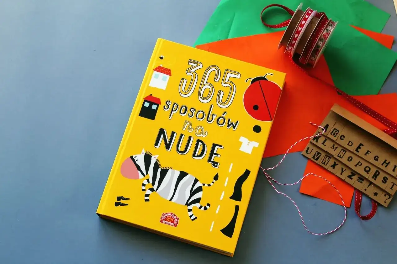 Żółta książka "365 sposobów na nudę" z zebrą, biedronką i literami.