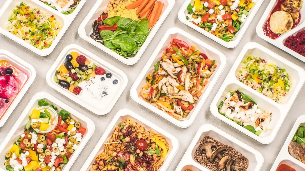 Catering dietetyczny co to? Różnorodne, zdrowe posiłki w wygodnych pojemnikach: sałatki, dania z kurczakiem, kaszą, owocami i warzywami.