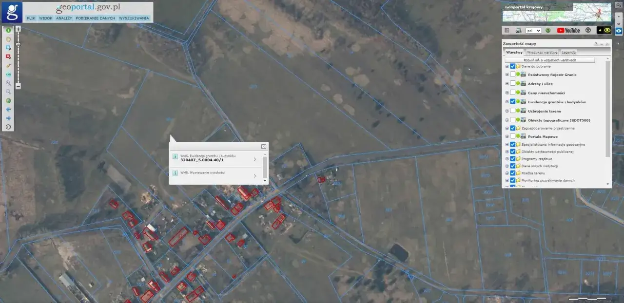 Widok mapy geoportalu z zaznaczonymi działkami i budynkami.