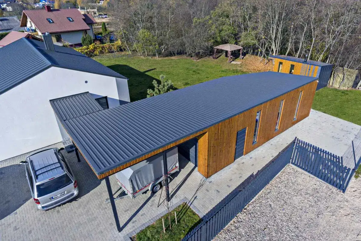 Nowoczesny budynek z dachem jednospadowym, drewnianą elewacją i zadaszeniem.