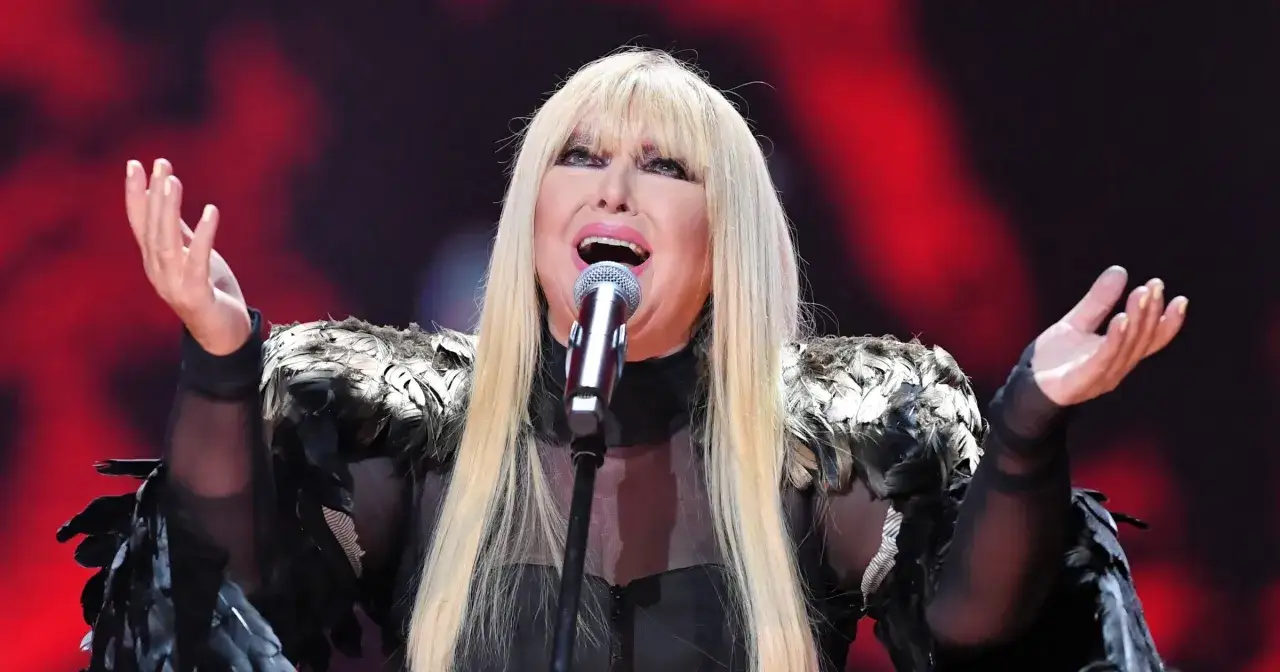 Gwiazda z piórami na ramionach śpiewa do mikrofonu, jakby to ona pierwsza śpiewała kolorowe jarmarki.