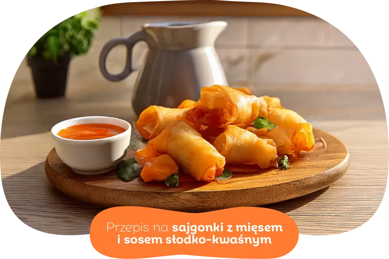 Chrupiące wege sajgonki z warzywami i sosem słodko-kwaśnym na drewnianej desce. Idealne na przekąskę.