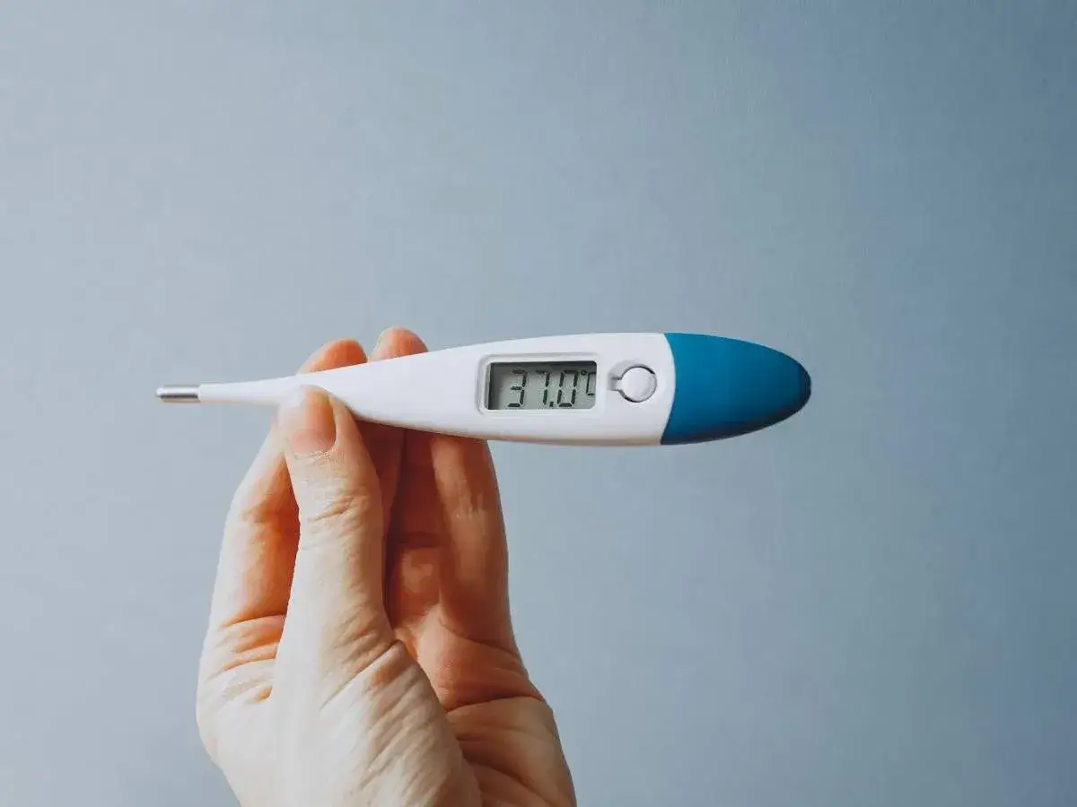 Dłoń trzyma cyfrowy termometr pokazujący 37.0°C. Kto wymyślił termometr? To pytanie zadaje sobie wielu, gdy mierzą temperaturę.
