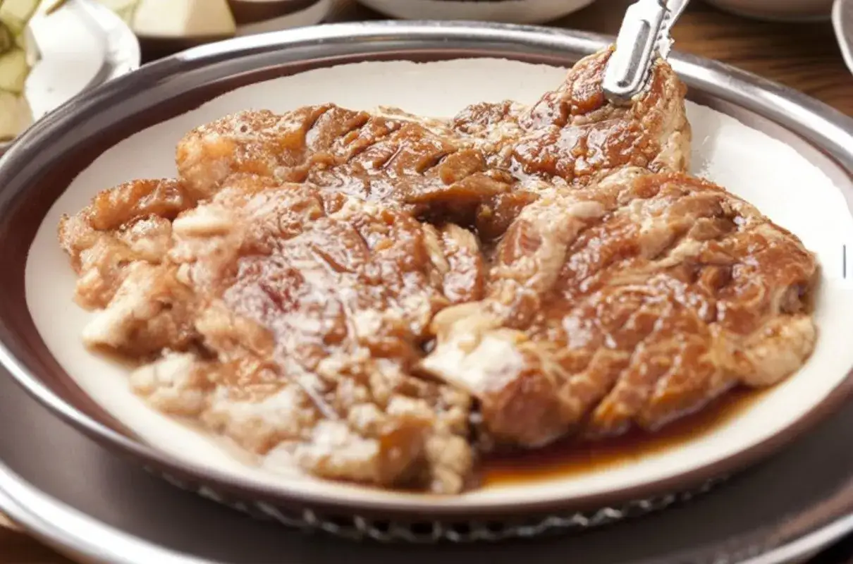 Soczysta karkówka z sosem sojowym i ketchupem, gotowa do grillowania.