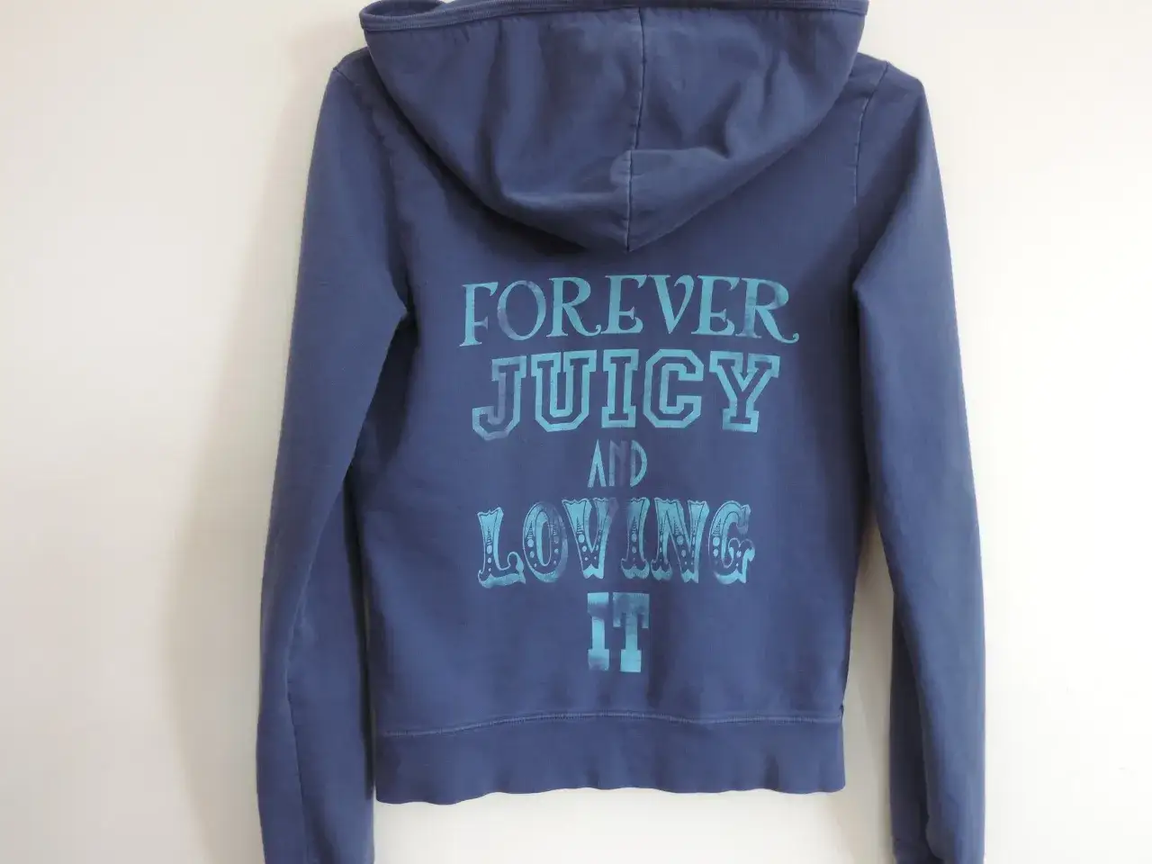 Granatowa bluza Juicy Couture z napisem "FOREVER JUICY AND LOVING IT" w turkusowym kolorze.
