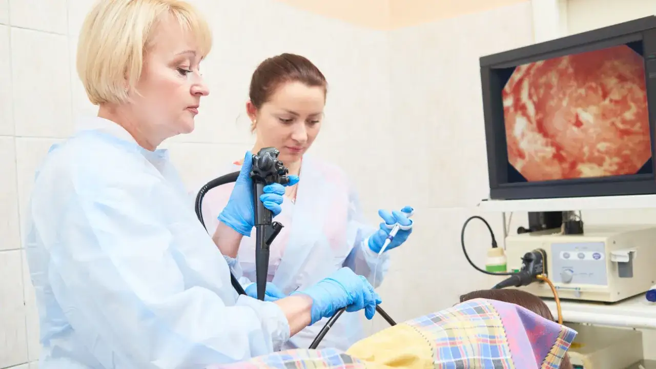 Lekarze wykonują gastroskopię, badanie wnętrza żołądka, obserwując obraz na monitorze.