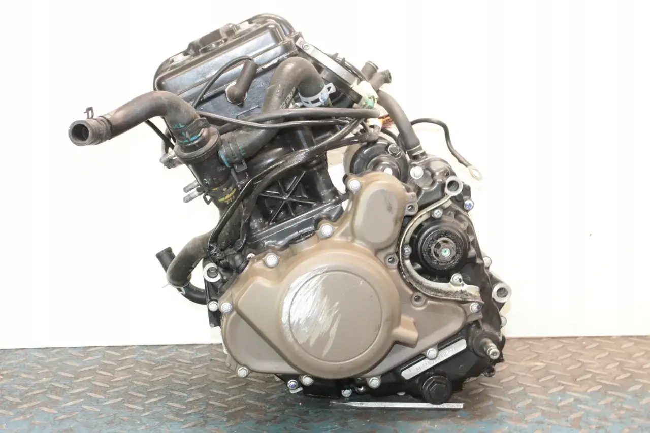 Silnik motocyklowy Husqvarna 125 z widocznymi przewodami i elementami obudowy.