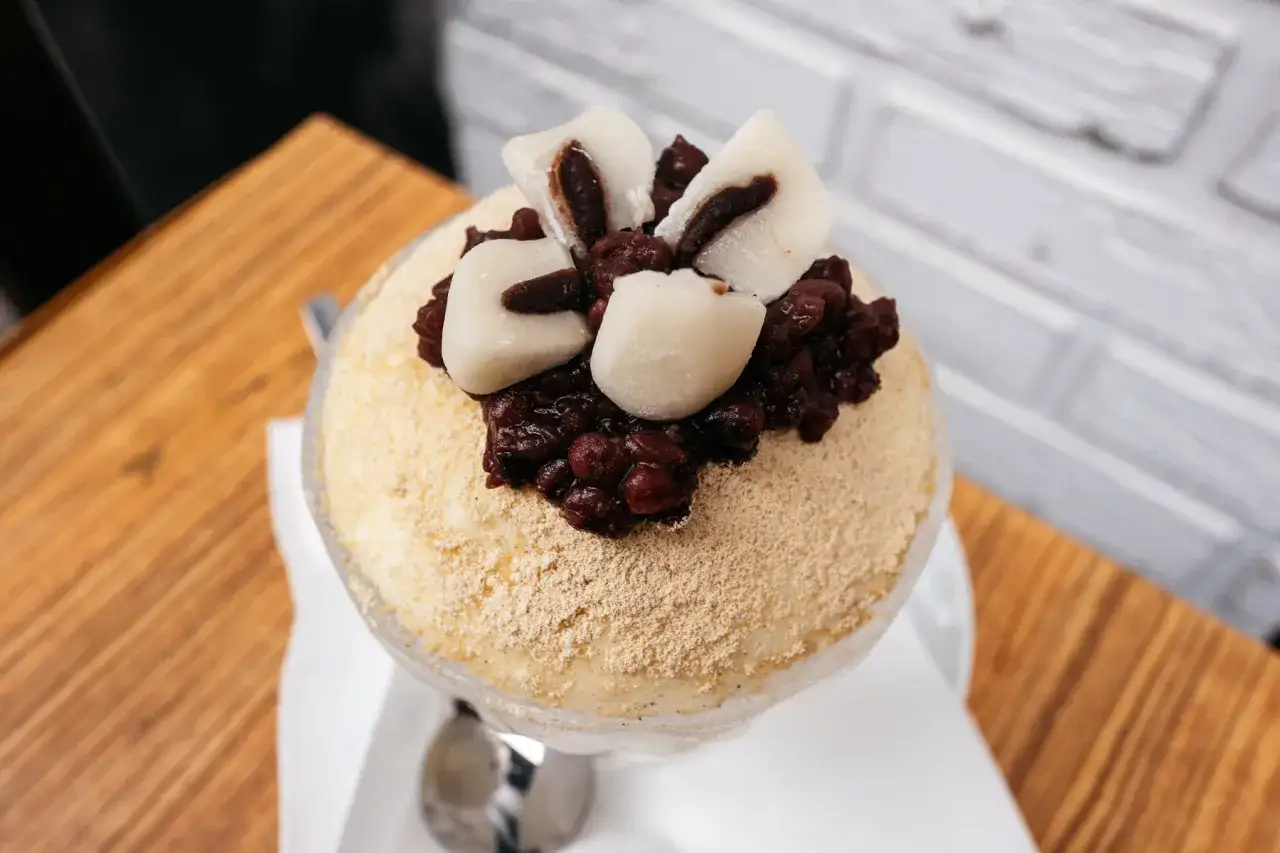 Puszysty deser lodowy posypany mąką sojową, z fasolką adzuki i kluskami mochi. Inspiracja koreańskimi przepisami na ciasta.